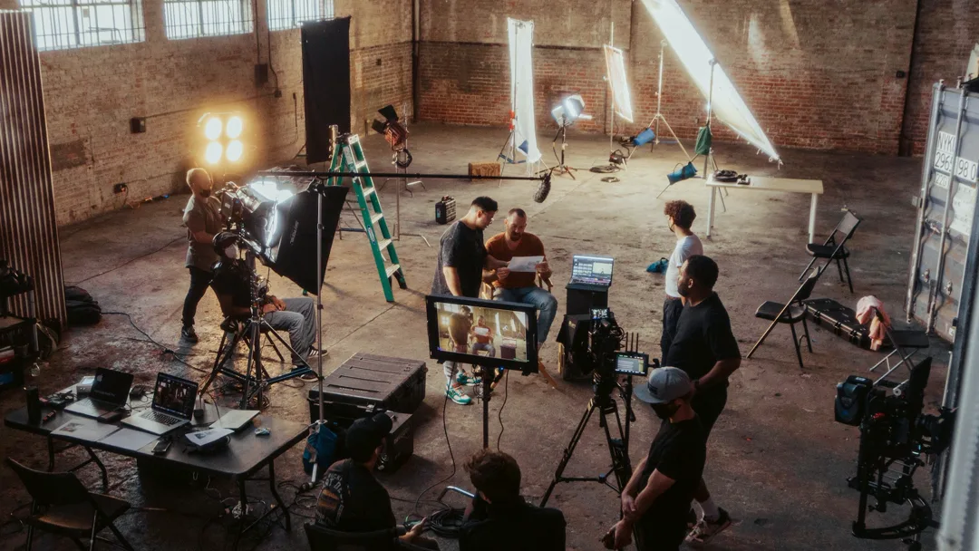 Equipo de rodaje trabajando con cámaras y luces en un set de producción audiovisual